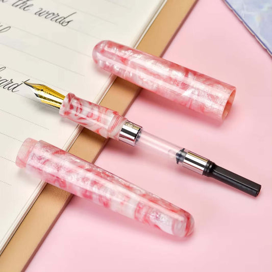 Kolorowe pióro wieczne River of Colors z odkręcaną skuwką, stalówką EF i tłoczkiem na tle notesu.